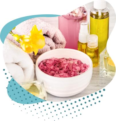 Mesa com materiais de esfoliação, como sal, óleos e toalhas e uma flor amarela enfeitando