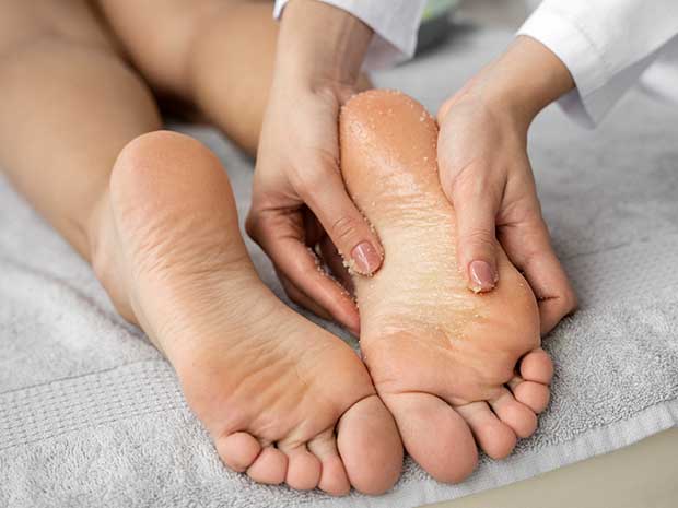 Profissional aplicando peeling nos pés da cliente.